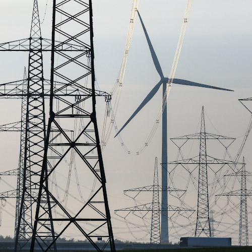 Netzerweiterung 380 KV, Leiterseile glaenzen im Abendlicht vor dazwischen Windenergieanlage. Bei Bernau, Land Brandenburg 2022