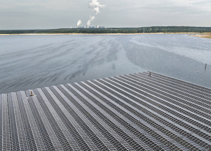 LEAG Aufbau Schwimmender Solarpark auf Cottbusser Bergbaufolgesee Der Ostsee vor Kulisse Braunkohlenkraftwerk Jänschwalde Sommer 2024