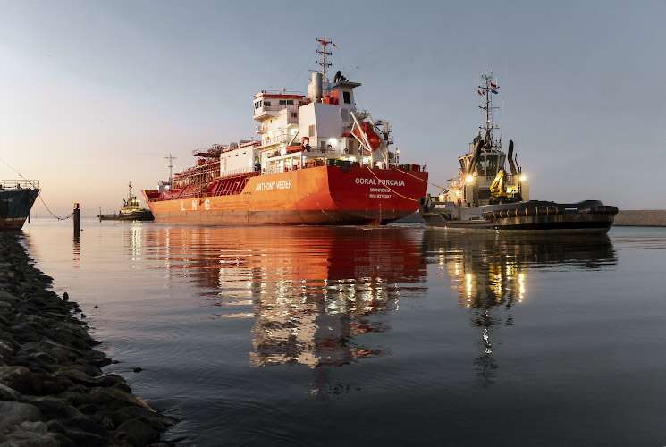 Floating LNG Terminal Neptune. Shuttle Tanker Coral Furcata tugged into Lubmin Inner Harbour. Baltic Sea Germany 2023
